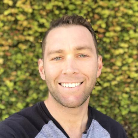 A head shot of Caleb Winters smiling. Caleb is a white man with short brown hair and blue eyes, wearing a gray t-shirt